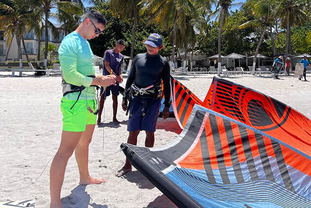 Group of students organizing the kiteboarding equipment to go out sailing